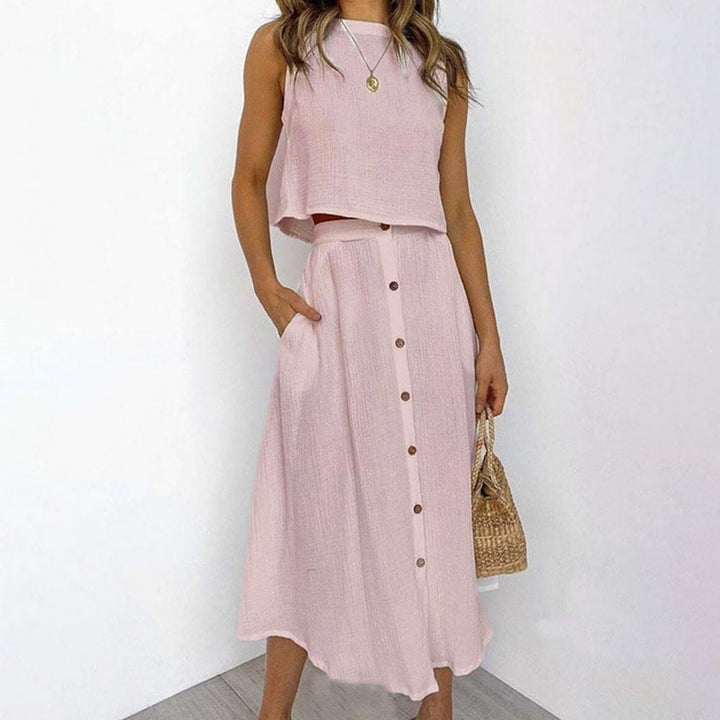 Frau in rosa Leinen-Zweiteiler, ärmelloses Top, Knopfleiste, Sommermode, Strohtasche.
