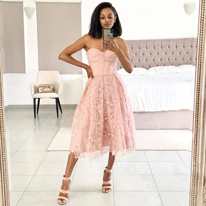 Frau im rosa Spitzenkleid, schulterfrei, Spiegel-Selfie, elegantes Schlafzimmer, Mode-Outfit.