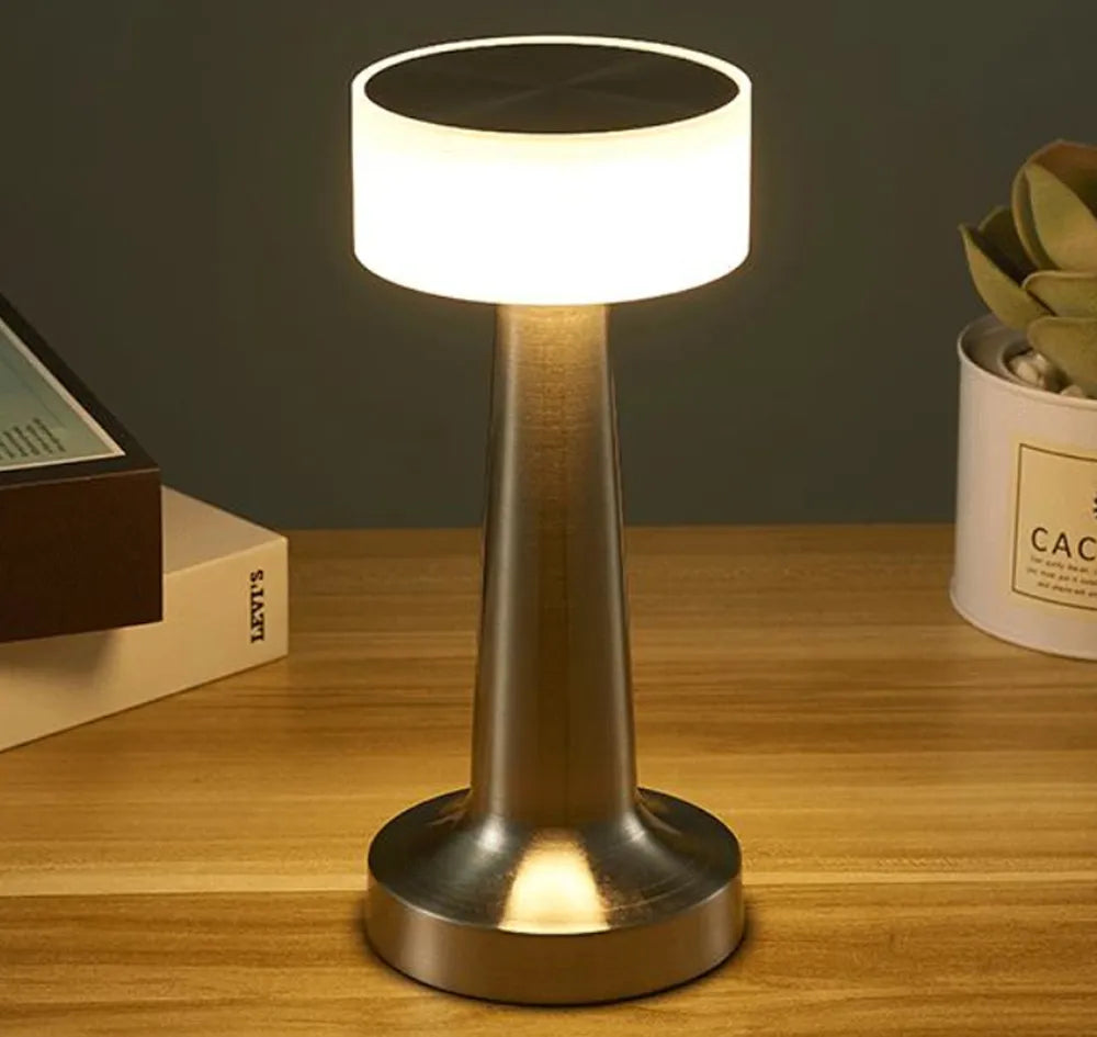 Moderne LED-Tischlampe aus Metall, warmweißes Licht, ideal für Wohnzimmer oder Büro.