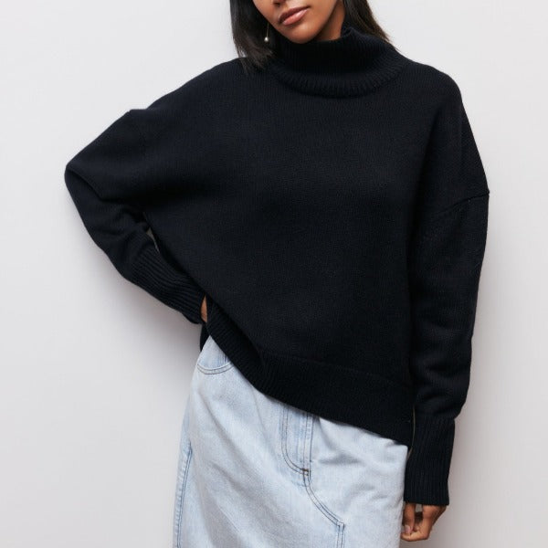Frau in schwarzem Rollkragenpullover und hellblauem Jeansrock vor weißem Hintergrund.