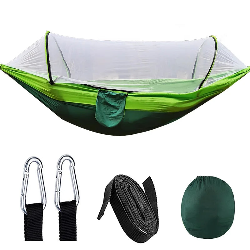 Grüne Hängematte mit Moskitonetz, Karabiner, Gurten und Tragetasche für Outdoor-Camping.