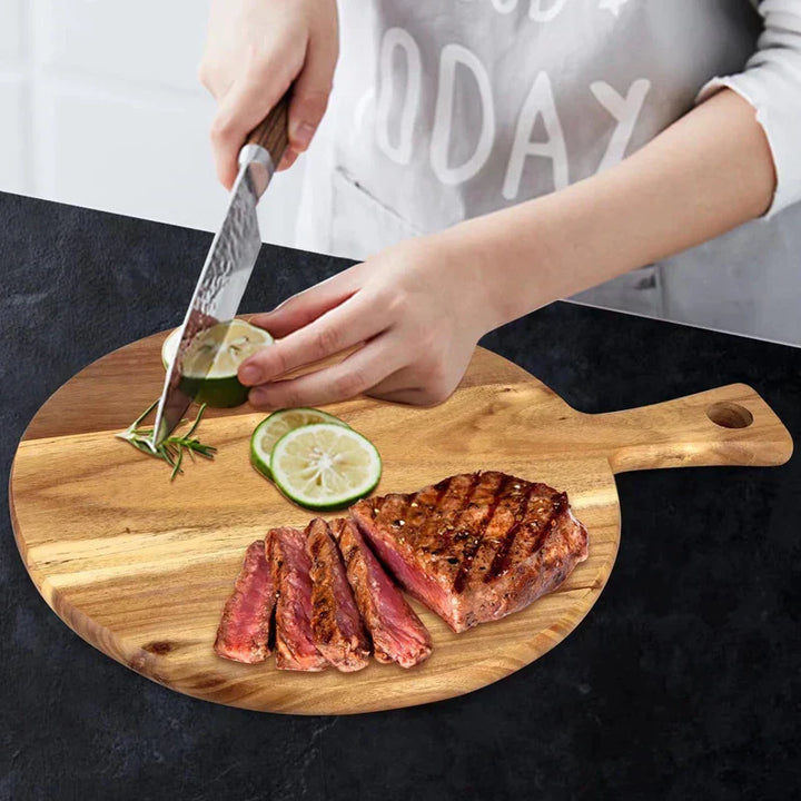Person schneidet Limette auf Holzbrett mit gegrilltem Steak, Küche, Kochen, Zubereitung.