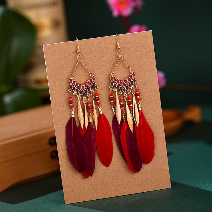 Rote und violette Federohrringe mit goldenen Akzenten, Boho-Stil, handgefertigt.