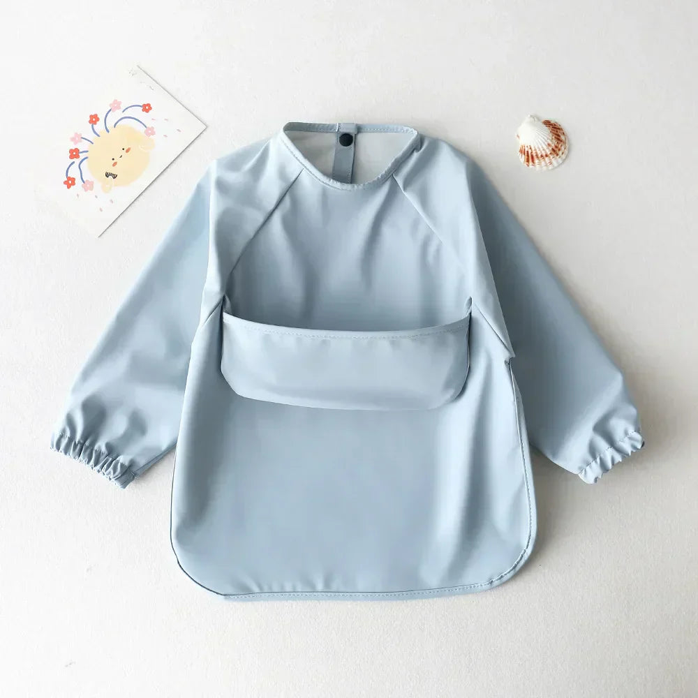 Hellblaues Kinder-Lätzchen mit langen Ärmeln, wasserdicht, ideal für Mahlzeiten und Basteln.