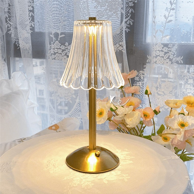 Goldene Tischlampe mit transparentem Lampenschirm, ideal für Wohnzimmerdekoration.