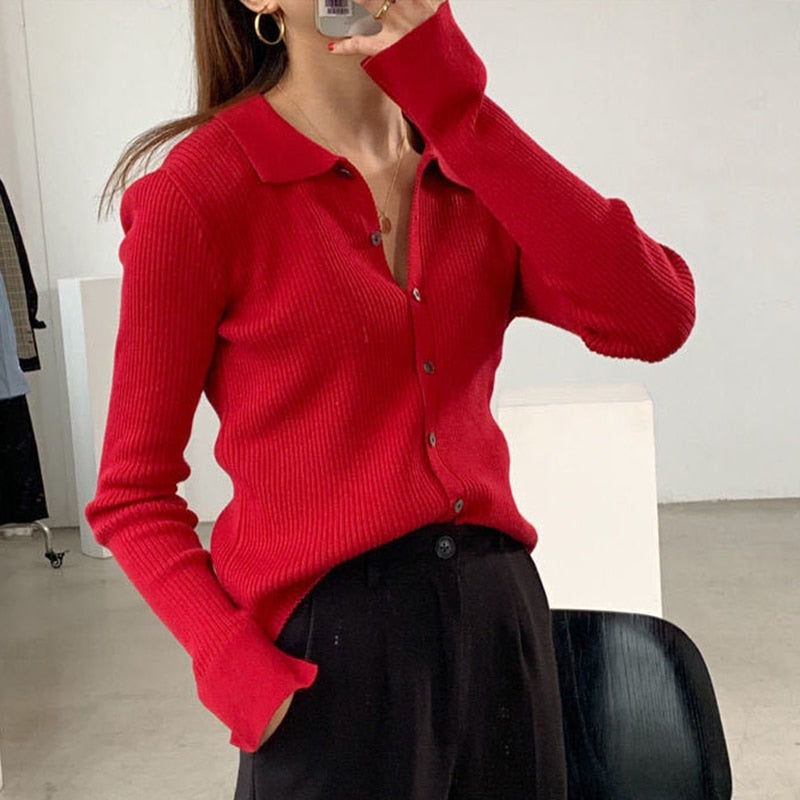 Frau in rotem Strickcardigan, schwarze Hose, modernes Outfit, modische Damenbekleidung.