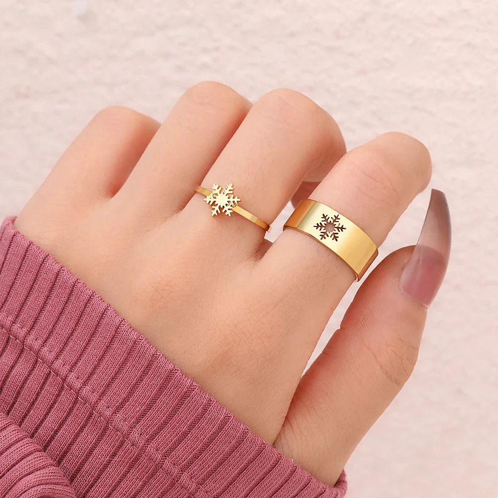 Goldene Schneeflockenringe auf Hand, modisches Schmuckdesign, Damenaccessoire.