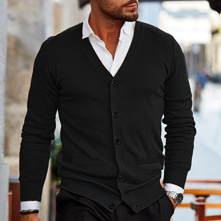 Mann in schwarzem Strick-Cardigan und weißem Hemd, eleganter Herrenmode-Look, Stadtumgebung.