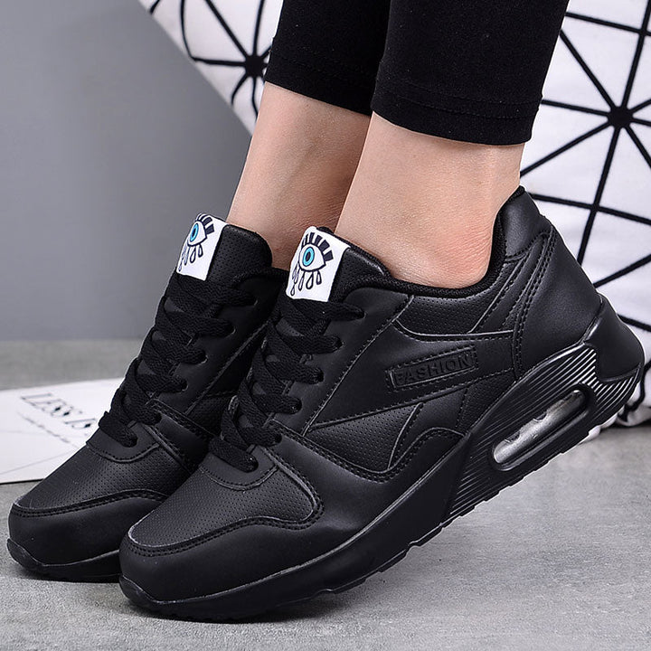 Schwarze Damen-Sneaker, Lederoptik, modisches Design, sportlich, bequem, mit Augen-Detail.