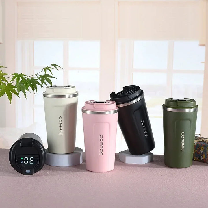 Fünf Thermobecher in verschiedenen Farben auf einem Tisch, ideal für Kaffee unterwegs.