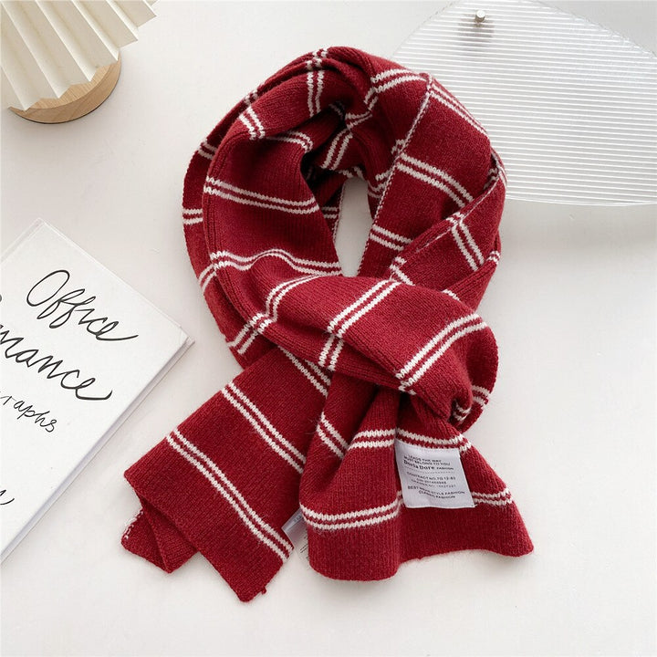 Roter Schal mit weißen Streifen, weiches Material, modisches Accessoire für Herbst und Winter.