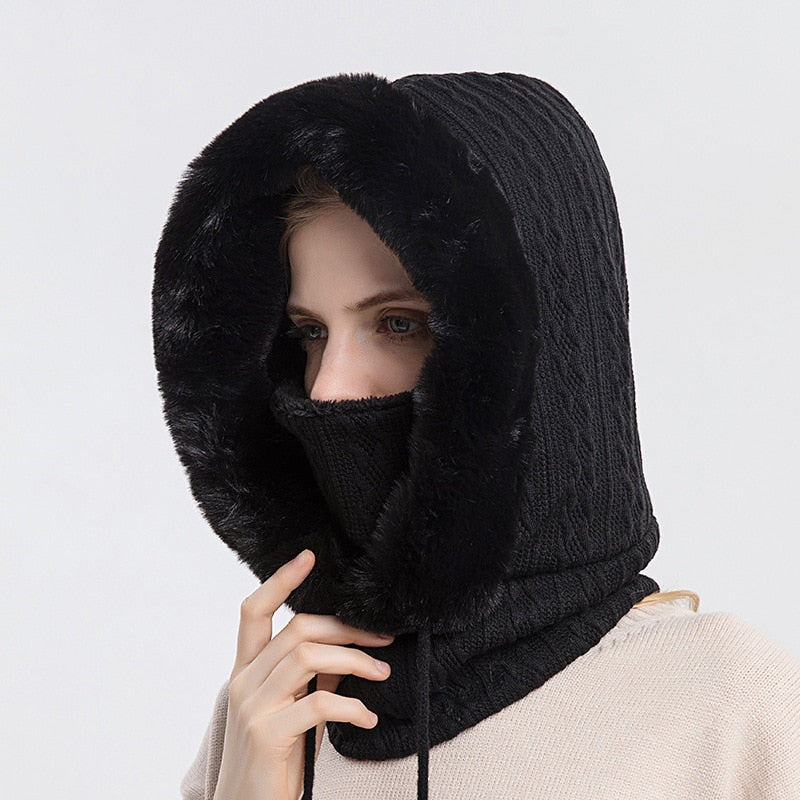 Frau mit schwarzem Strickschal und Kapuze aus Kunstpelz, winterliche Modeaccessoires.