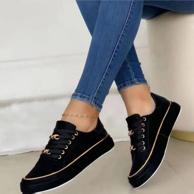 Schwarze Damen-Sneaker mit goldenen Details, Jeans, modisch, bequem, Freizeitlook.