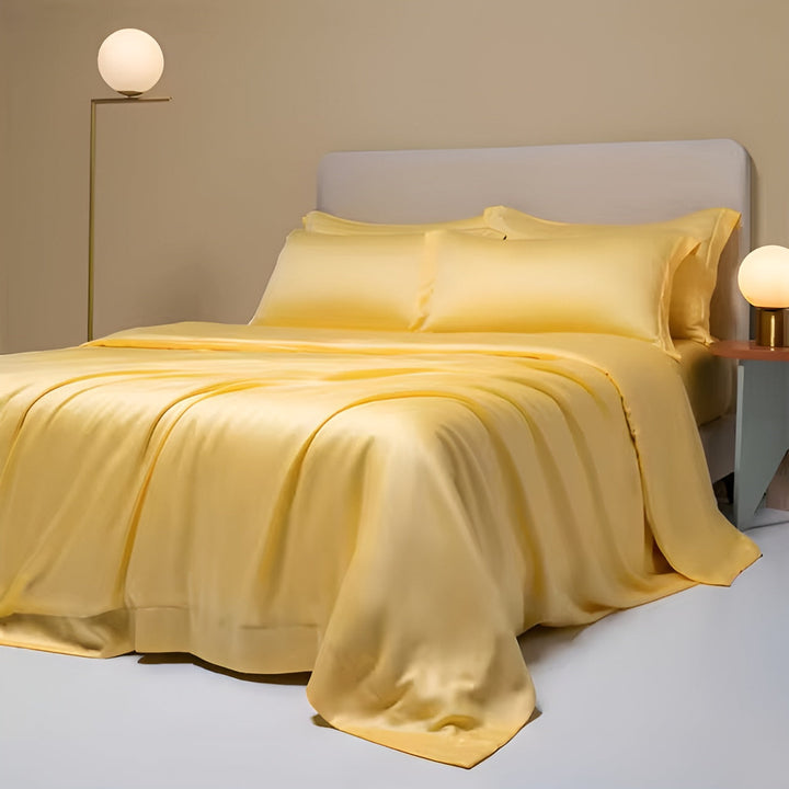 Gelbes Seidensatin-Bettwäsche-Set aus Bambus, luxuriös und atmungsaktiv, auf einem Bett drapiert.