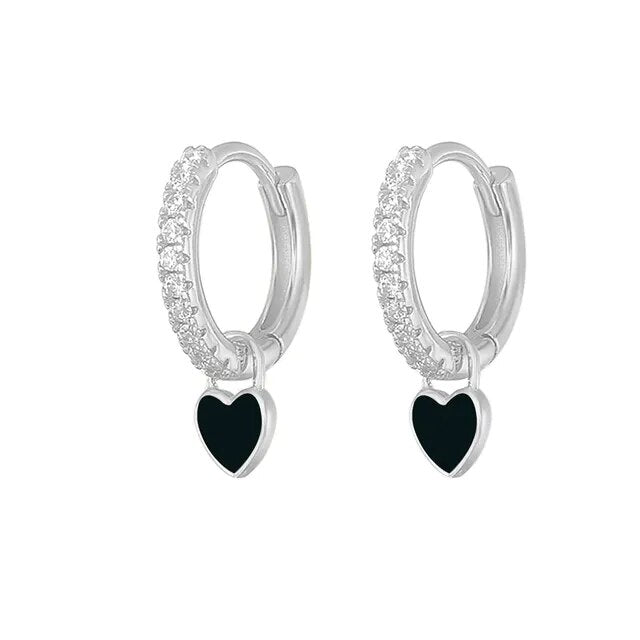 Silberne Creolen mit schwarzen Herzanhängern und Kristallverzierung, eleganter Schmuck.
