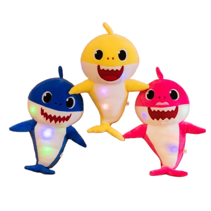 Drei leuchtende Baby Shark Plüschtiere in Blau, Gelb und Pink, singend, Kinder Spielzeug.