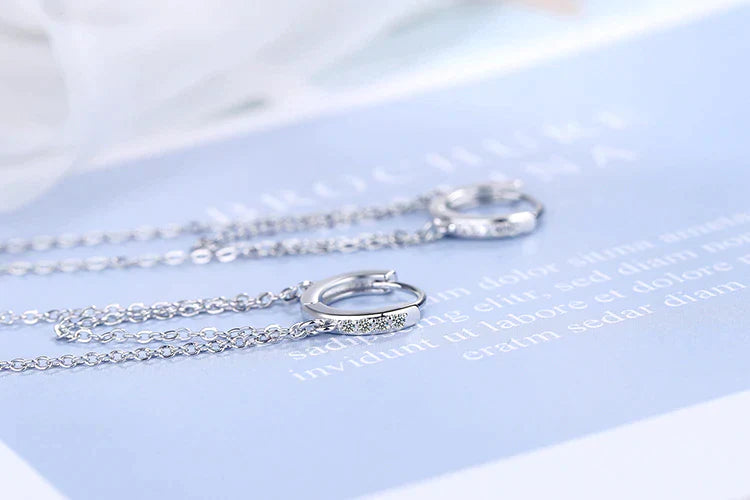 Silberne Creolen mit Kette, elegantes Design, Schmuck für Damen, modisch und stilvoll.