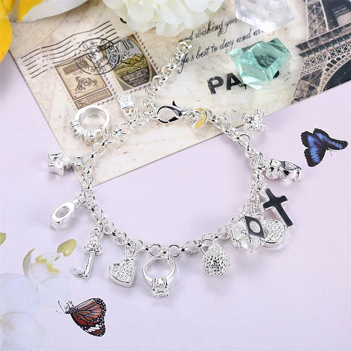 Silbernes Charm-Armband mit Anhängern, Kreuz, Herz, Notenschlüssel, ideal als Geschenk.