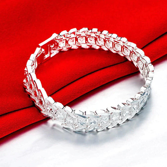 Silbernes Armband mit Diamantmuster auf rotem Stoff, elegantes Schmuckdesign.