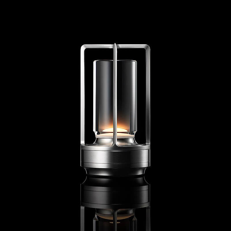 Svítící lampa se stříbrným kovovým rámem a skleněným válcem na černém pozadí, studiový snímek s odrazem. 10