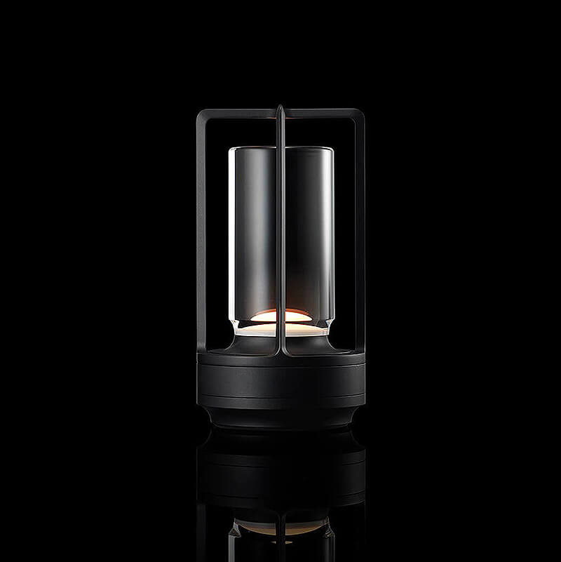 Svítící lampa s černým kovovým rámem a skleněným válcem na černém pozadí, studiový snímek s odrazem. 11