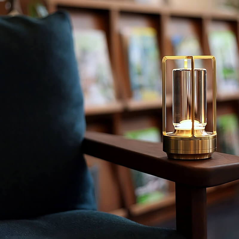 Zlatá svítící lampa stojí na dřevěné područce křesla, v pozadí je rozmazaná knihovna. 8