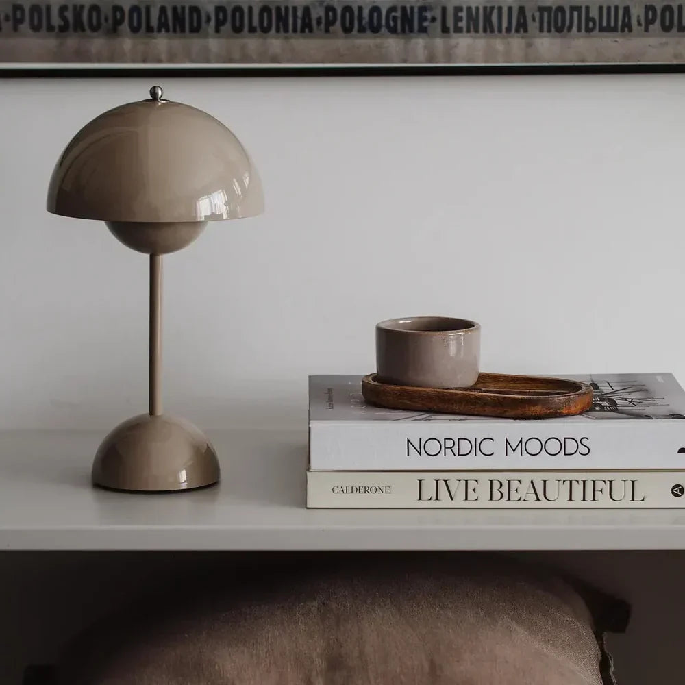 Beige Tischlampe und Tasse auf Bücherstapel, skandinavisches Design, Wohnzimmerdekoration.