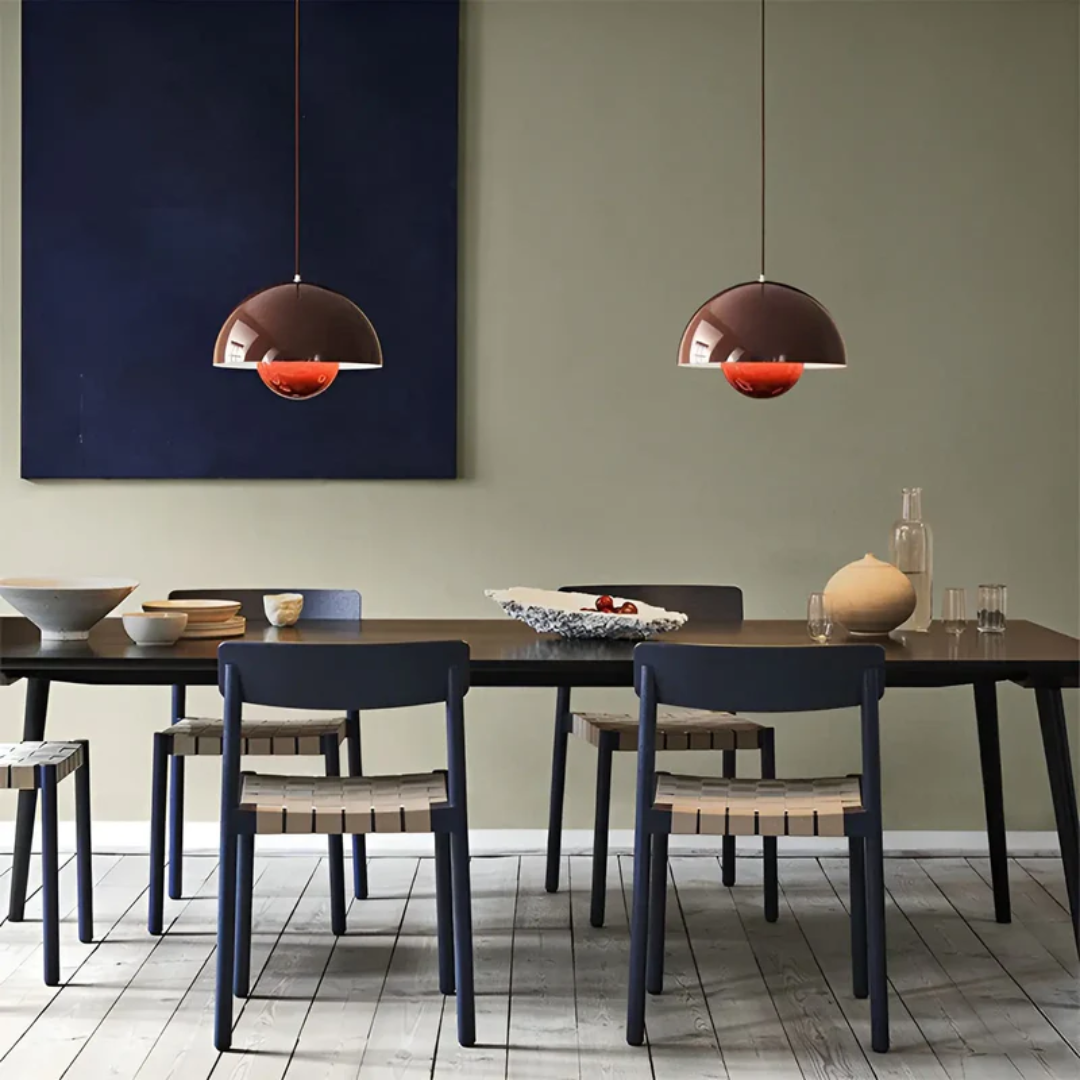 Moderne Esszimmer mit braunen Pendelleuchten, Holztisch, blauen Stühlen und Dekoration.