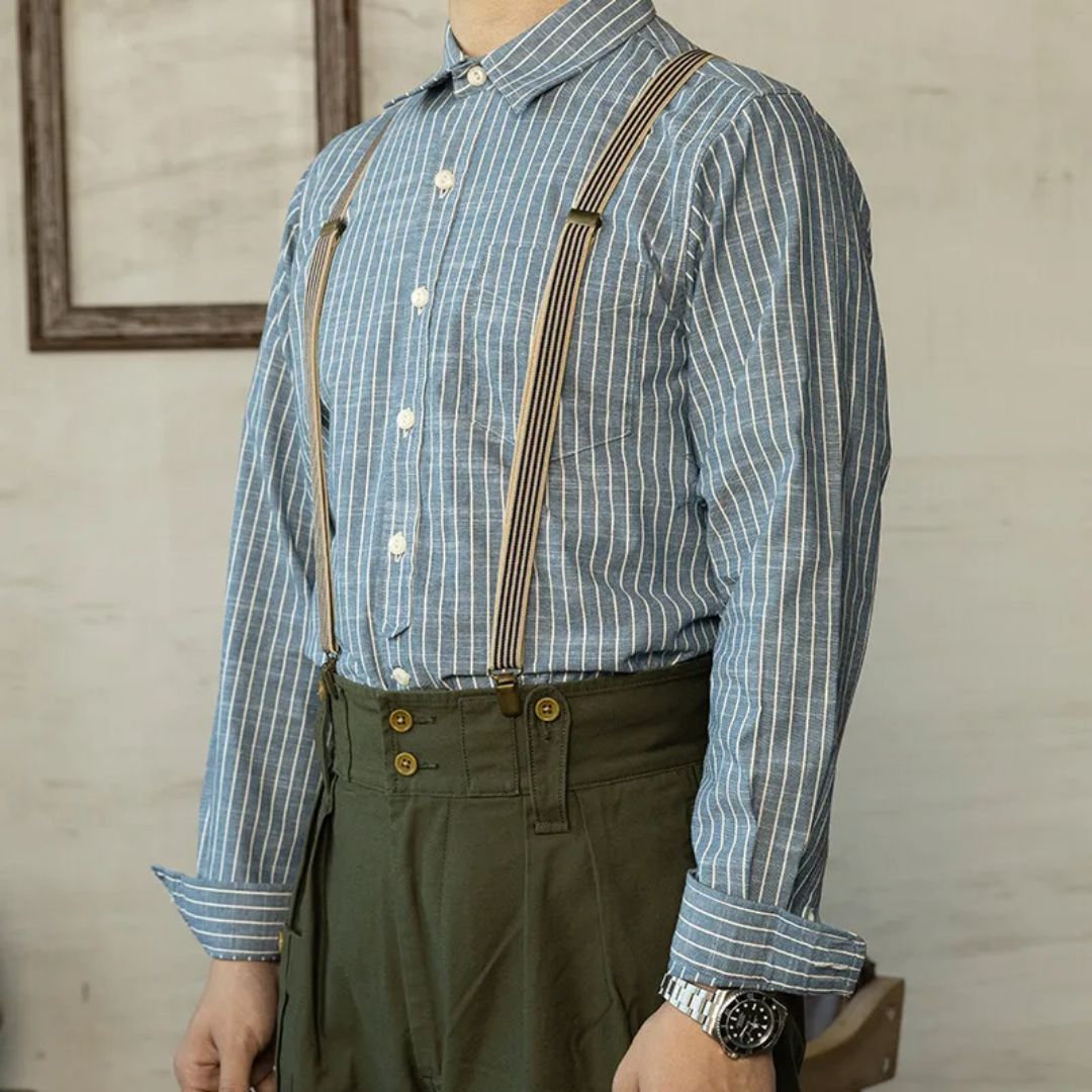 Mann mit blau-weiß gestreiftem Hemd und Hosenträgern, grüne Hose, Vintage-Stil.