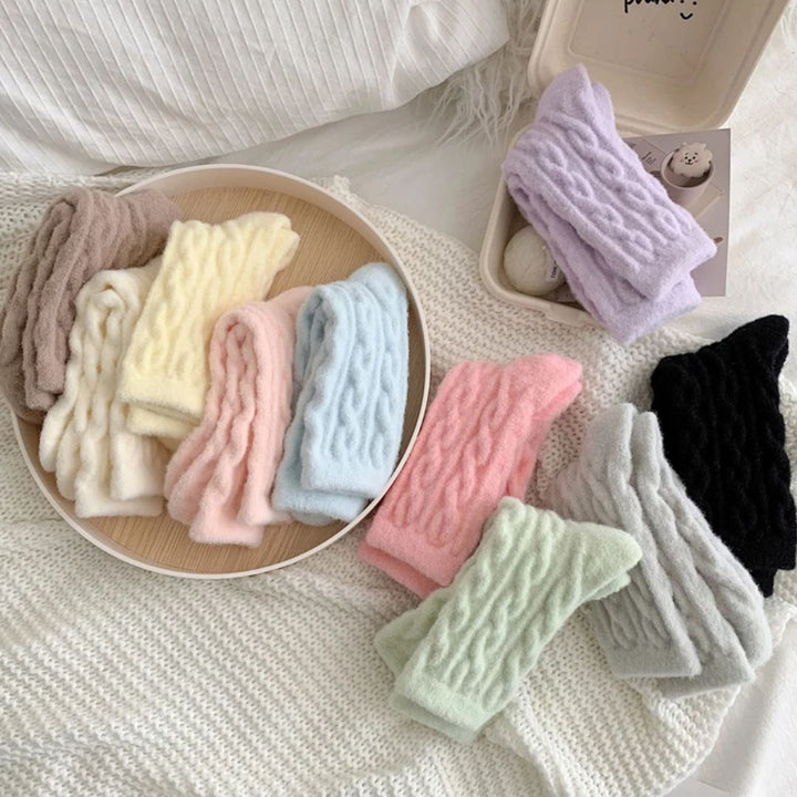 Vielseitige, bunte, gestrickte Stirnbänder aus Wolle auf einem Tablett, ideal für Wintermode.