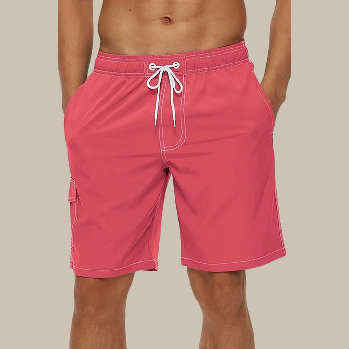 Rote Herren-Badeshorts mit Kordelzug, Taschen, ideal für Sommer und Strand.