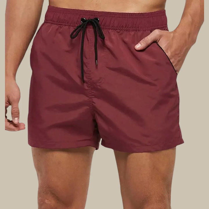 Rote Herren-Badeshorts mit Kordelzug, elastischer Bund, seitliche Taschen.