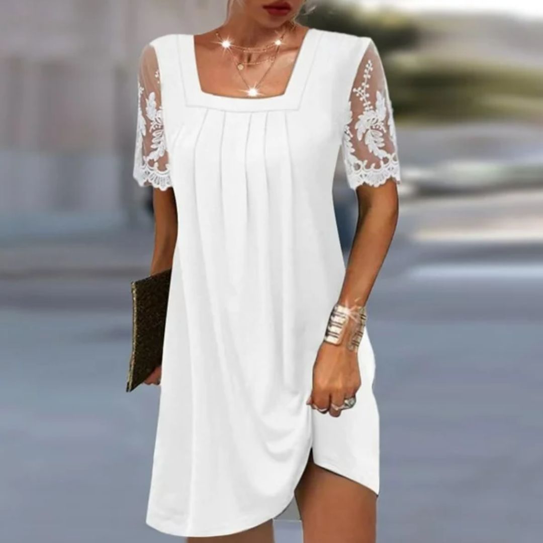 Frau in weißem Sommerkleid mit Spitzenärmeln, quadratischem Ausschnitt, hält Clutch.