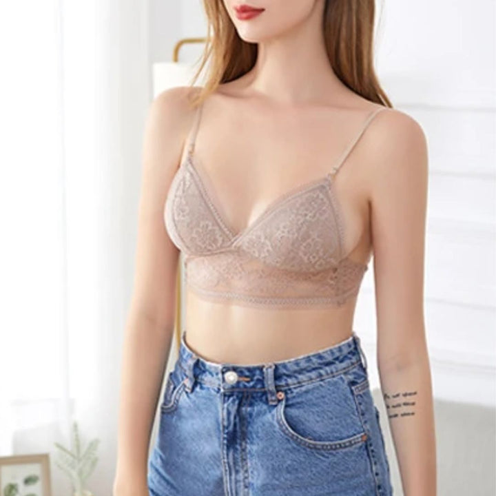 Frau trägt beige Spitzen-Bralette, Jeans; modische Damenunterwäsche, bequem, stilvoll.