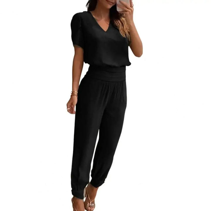 Frau in schwarzem Jumpsuit, V-Ausschnitt, kurze Ärmel, elegantes Design, Modekleidung.