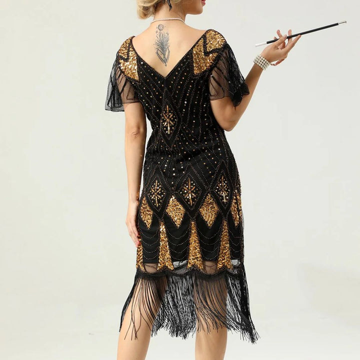 Frau im schwarzen, goldenen Fransen-Kleid mit Tattoo und Zigarettenspitze, Vintage-Stil.