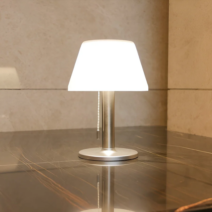 Moderne Tischlampe aus Metall mit weißem Schirm auf Marmortisch, Innenbeleuchtung.