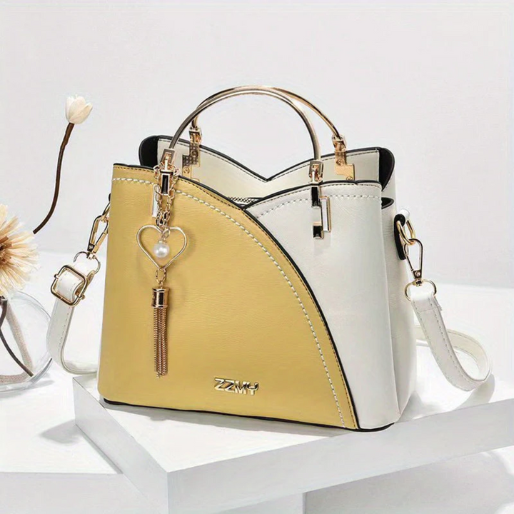 Zweifarbige Damenhandtasche, gelb-weiß, Leder, mit Herzanhänger, elegantes Design.