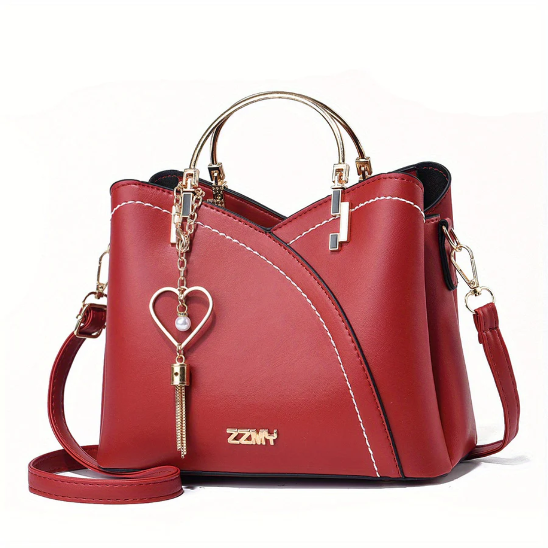 Rote Damenhandtasche aus Leder mit Herzanhänger, goldene Details, Umhängetasche.