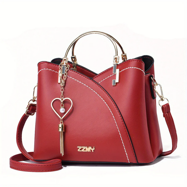 Rote Damenhandtasche aus Leder mit Herzanhänger, goldene Details, Umhängetasche.