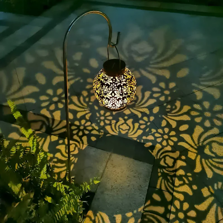 Solarbetriebene Gartenlaterne mit filigranem Muster, warmweißes Licht, dekorative Außenbeleuchtung.