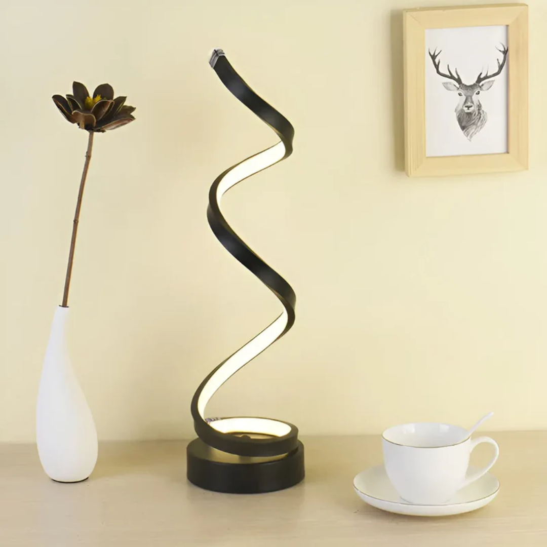 Schwarze LED-Tischlampe in Spiralform auf Holzoberfläche, moderne Inneneinrichtung.