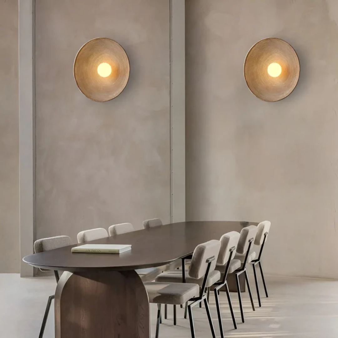Moderner Konferenzraum mit Holztisch, beige Stühlen und runden Wandleuchten aus Metall.