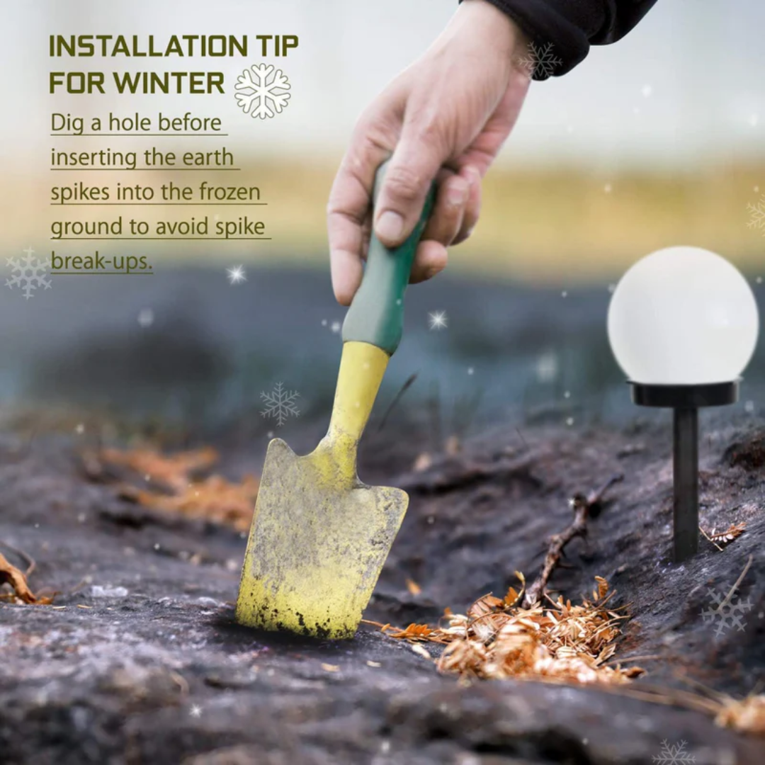 Hand hält gelben Gartenspaten, gräbt Erde neben Solarlampe im Winter, Installationstipps.