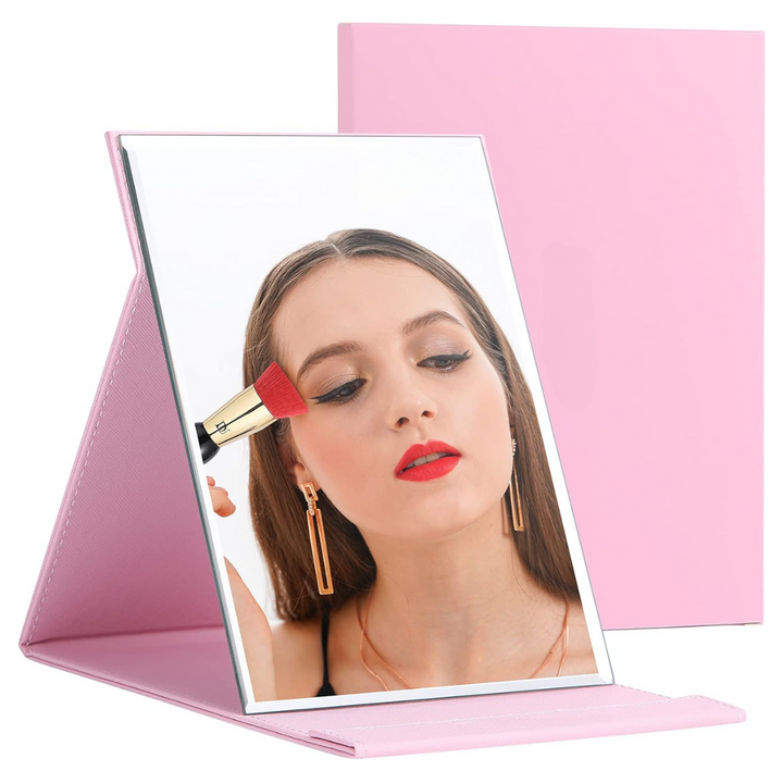 Rosa klappbarer Schminkspiegel mit Frau beim Schminken, ideal für Make-up und Reisen.