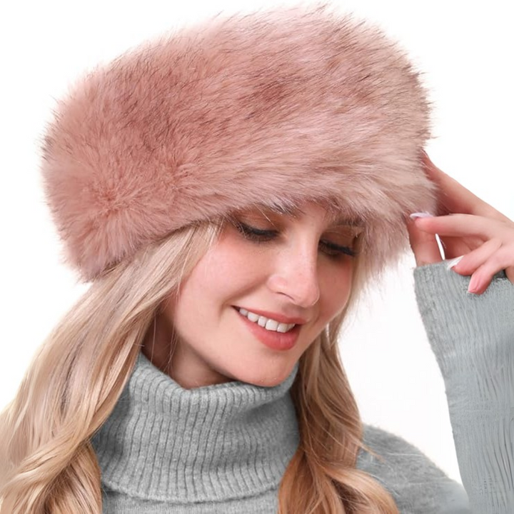 Frau mit rosa Kunstpelz-Stirnband, grauer Rollkragenpullover, Wintermode Accessoire.