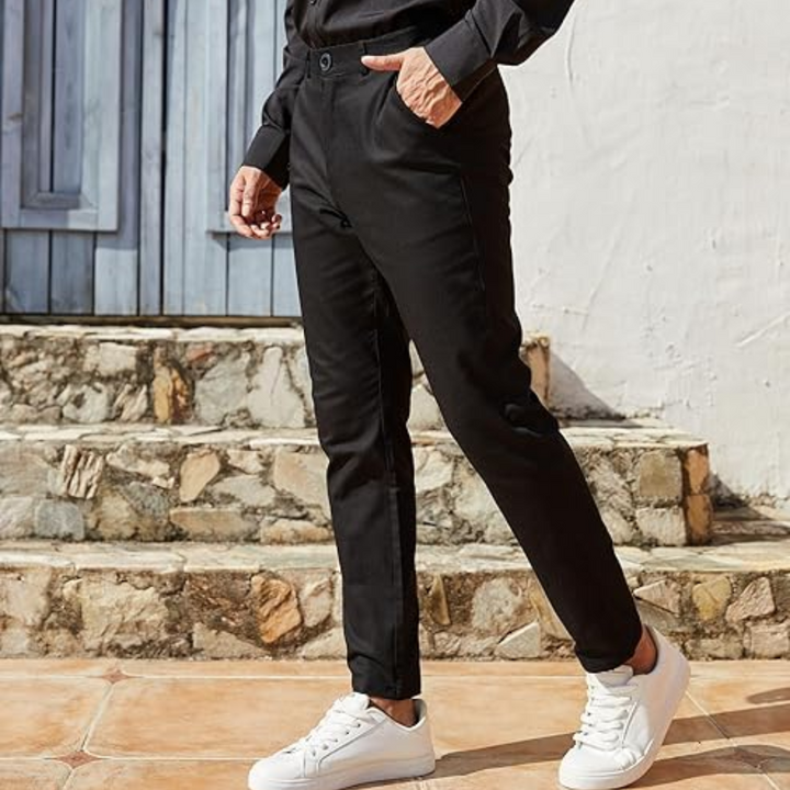 Mann in schwarzer Hose und weißen Sneakern vor blauer Tür, lässiger Herrenmode-Stil.