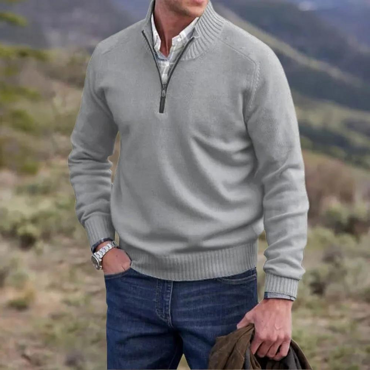 Mann in grauem Strickpullover mit Reißverschluss, lässig, Outdoor, Herbstmode, Herrenbekleidung.