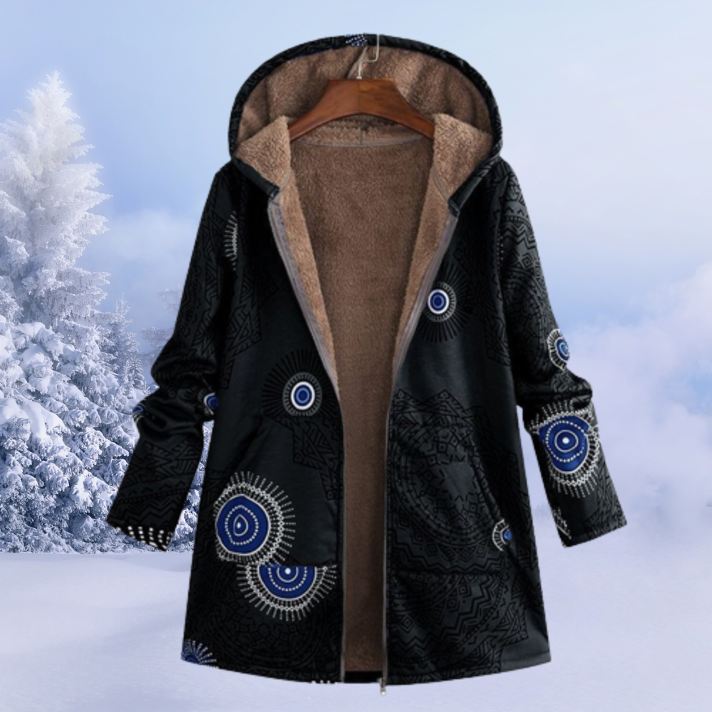 Schwarzer Damen-Wintermantel mit Kapuze, blauem Mandala-Muster, warm gefüttert, im Schnee.