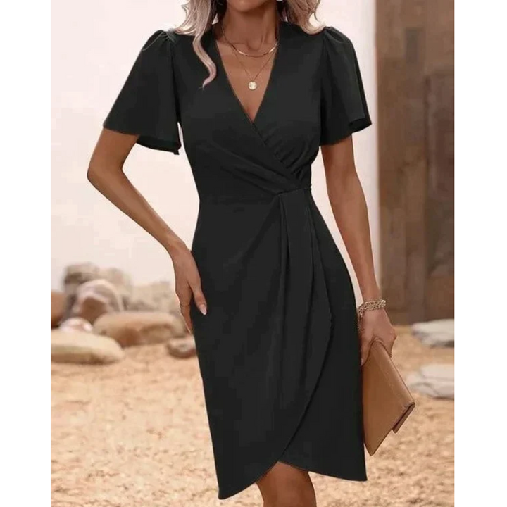 Frau in schwarzem Wickelkleid, V-Ausschnitt, kurze Ärmel, elegantes Design, draußen.